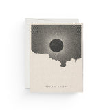 JONES + CO You Are a Light greeting card with a black sun illustration by Daren Thomas Magee on recycled paper.