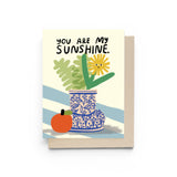 JONES + CO You Are My Sunshine greeting card featuring a whimsical flower in a blue patterned vase with an orange.