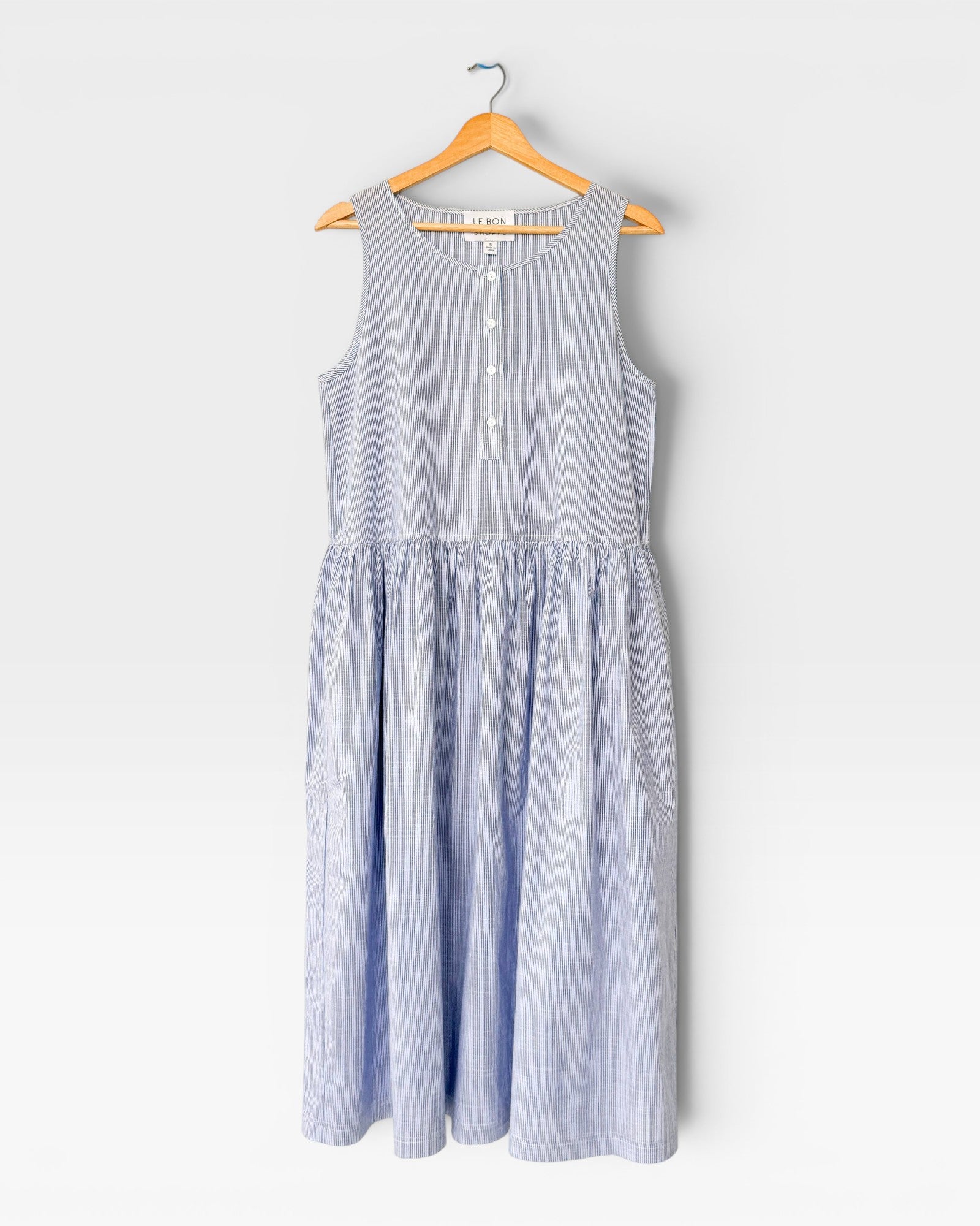 Light blue striped dress on a hanger against a white background