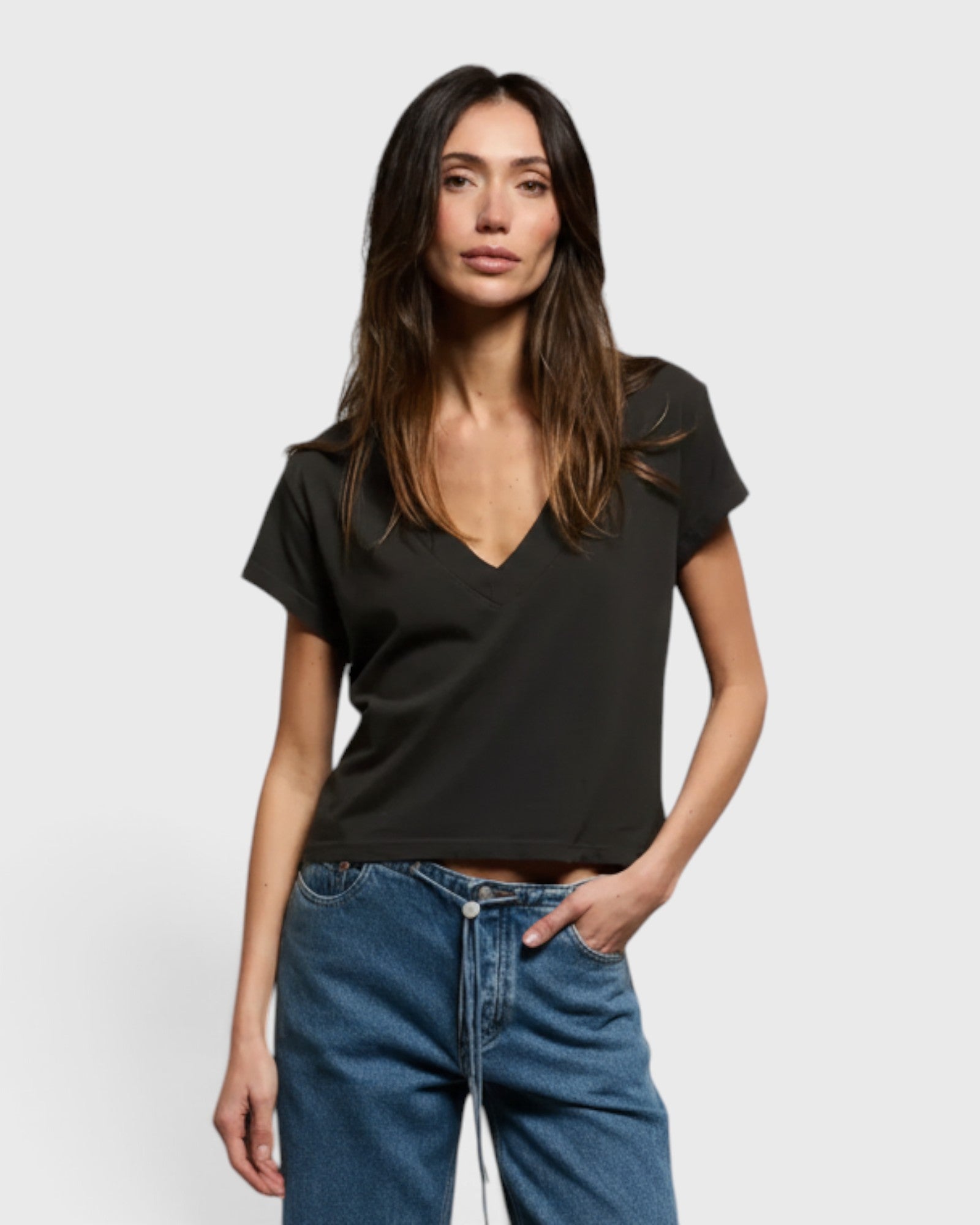 Model wearing a JONES + CO vintage black recycled cotton Alanis V-neck tee with a relaxed cropped fit.