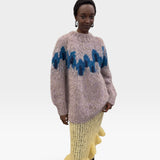 JONES + CO chunky superfine alpaca raglan pullover in peacock intarsia knit worn by a model with a yellow skirt.