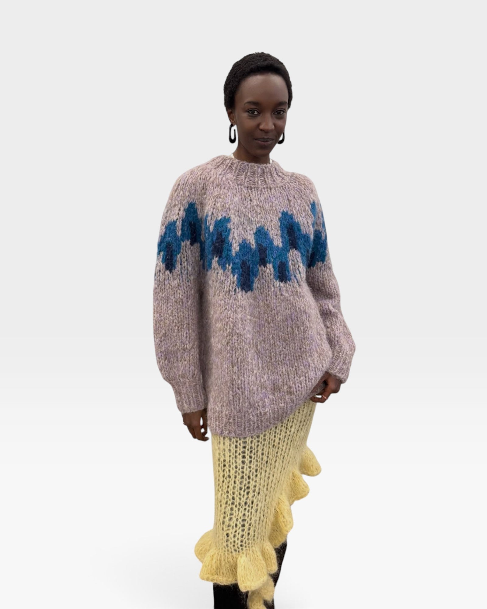 JONES + CO chunky superfine alpaca raglan pullover in peacock intarsia knit worn by a model with a yellow skirt.