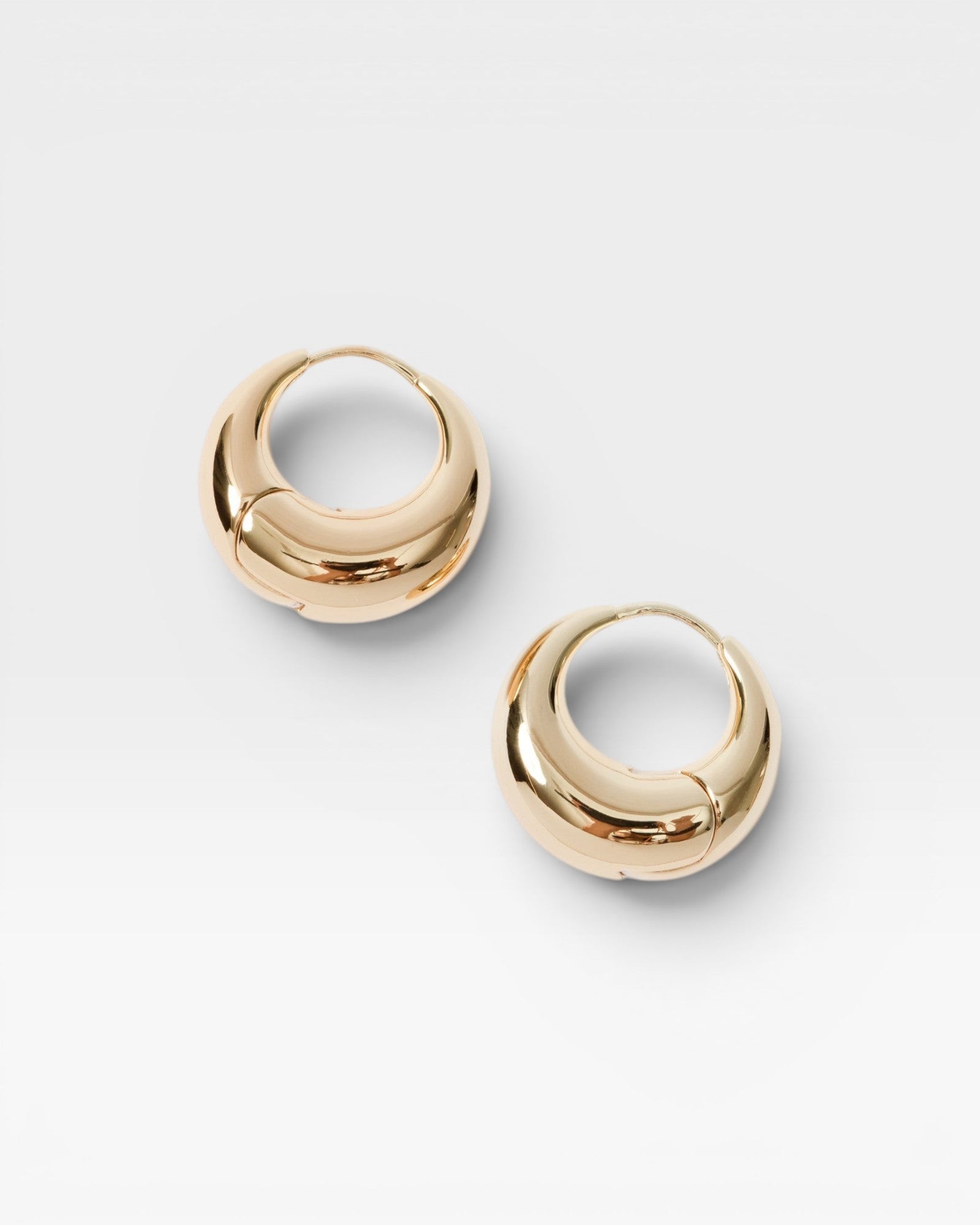 JONES + CO Alpha Hoop small chunky tapered huggie earrings in 12k gold-plated brass with hinge detail.