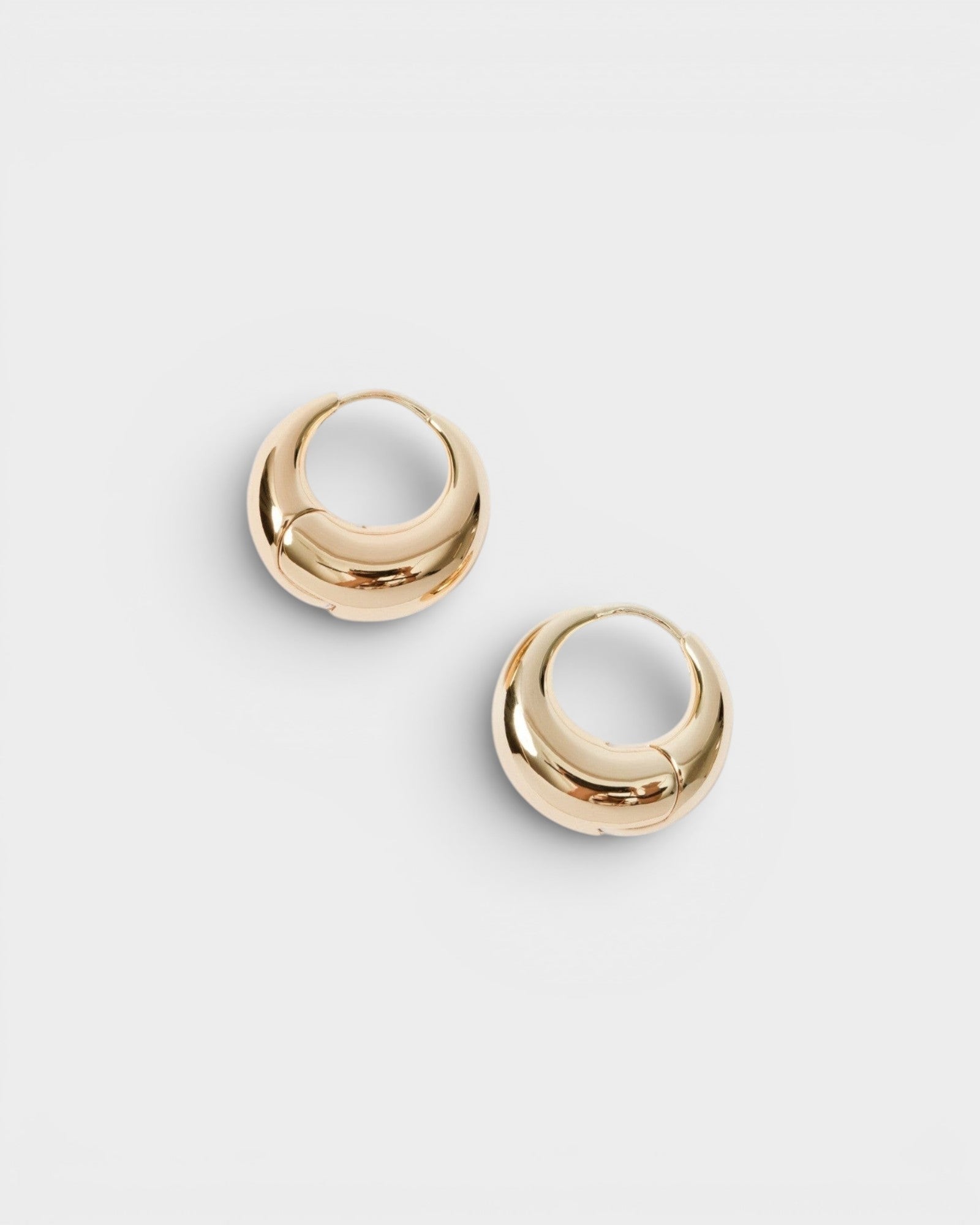 JONES + CO Alpha Hoop small chunky tapered huggie earrings in 12k gold-plated brass with hinge detail.