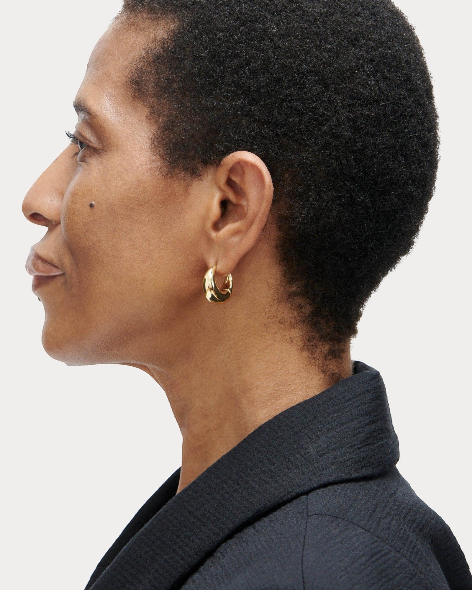JONES + CO Alpha Hoop small chunky tapered huggie earrings in 12k gold-plated brass with hinge detail.