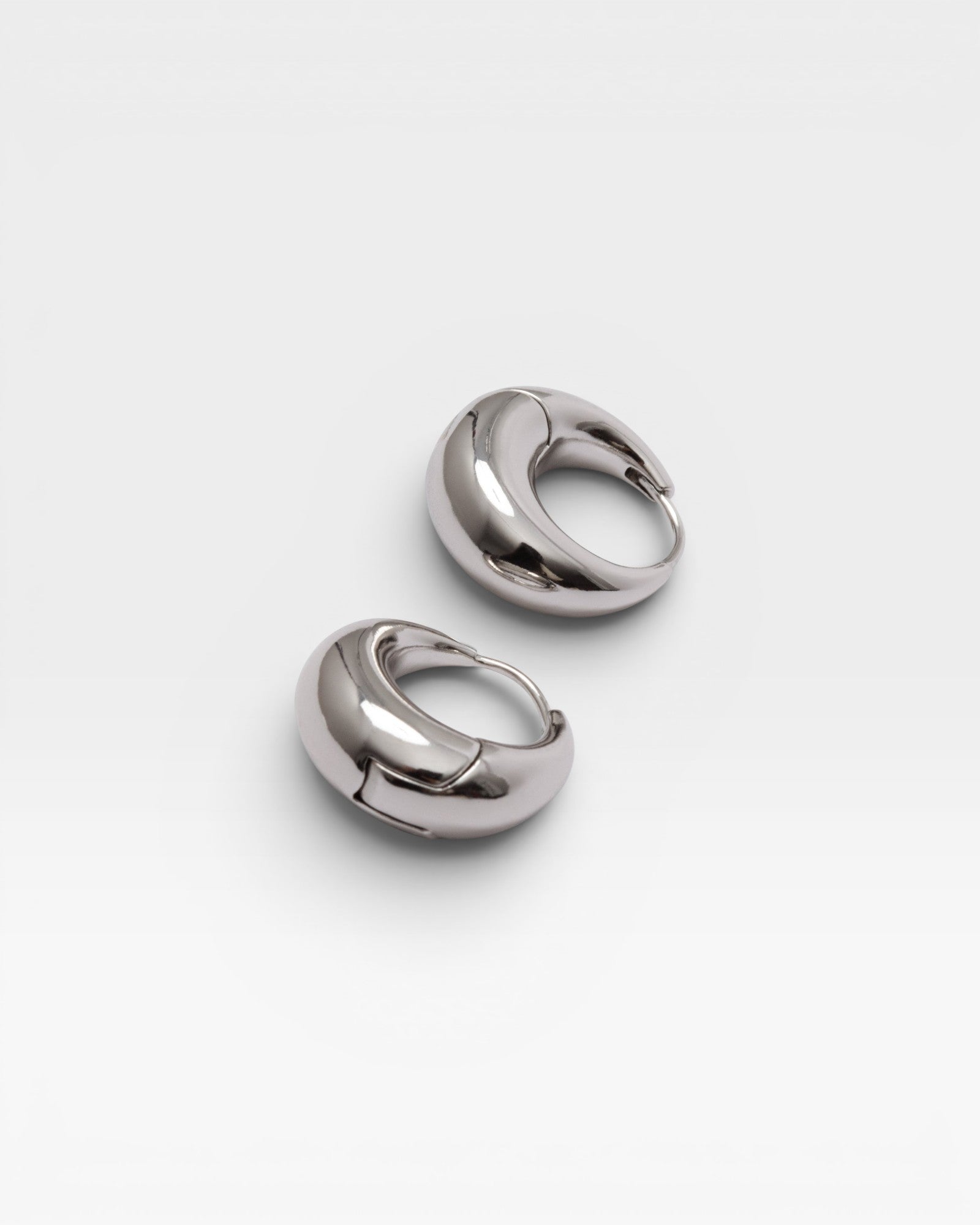 JONES + CO Alpha Hoop small chunky tapered huggie earrings in silver-plated brass with hinge detail.