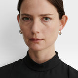 JONES + CO Alpha Hoop small chunky tapered huggie earrings in sterling silver-plated brass with hinge detail.