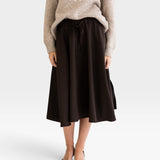 JONES + CO Angie skirt in chocolate brown with drawstring waist, side pockets, and slits, worn with a knit sweater.