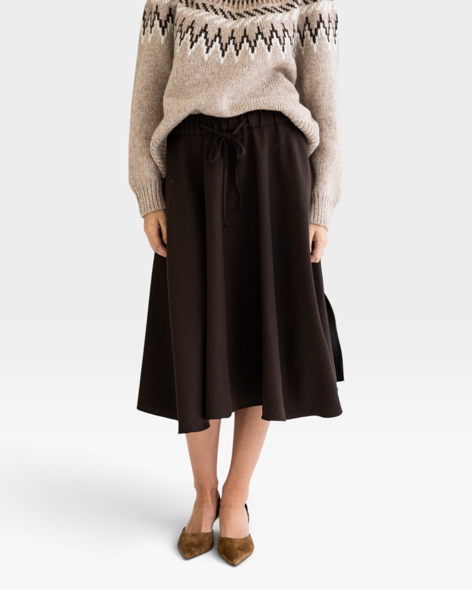 JONES + CO Angie skirt in chocolate brown with drawstring waist, side pockets, and slits, worn with a knit sweater.