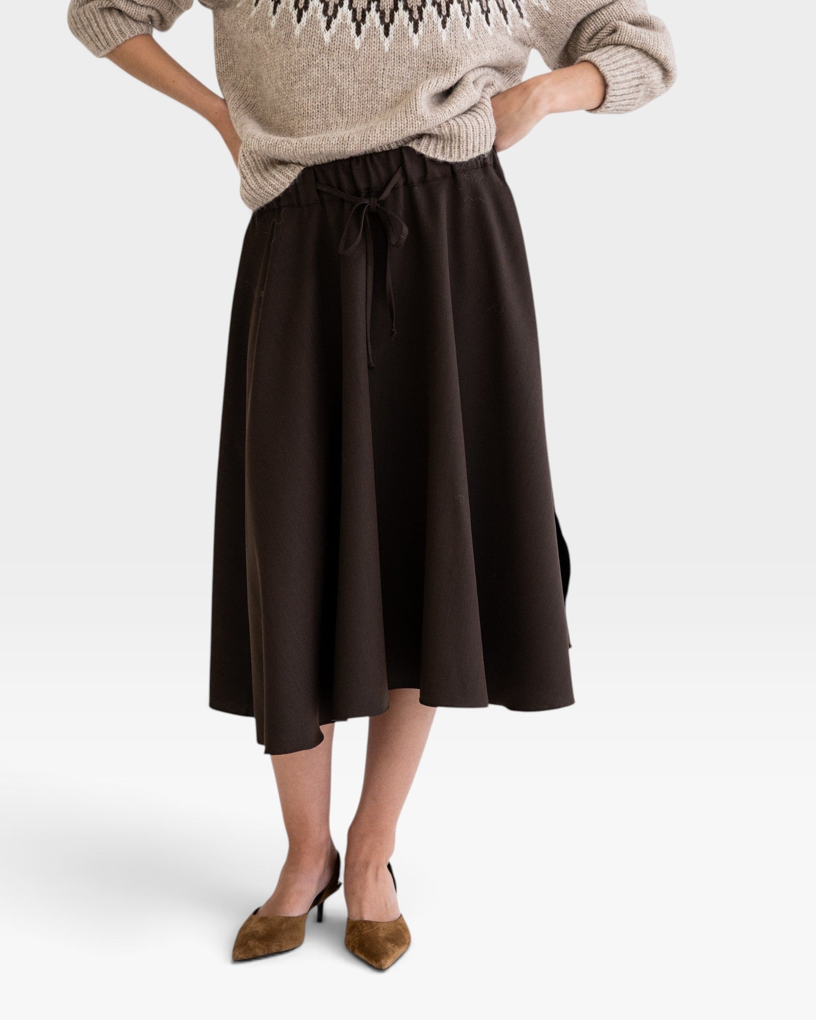 JONES + CO Angie skirt in chocolate brown with drawstring waist, side pockets, and slits, worn with a knit sweater.
