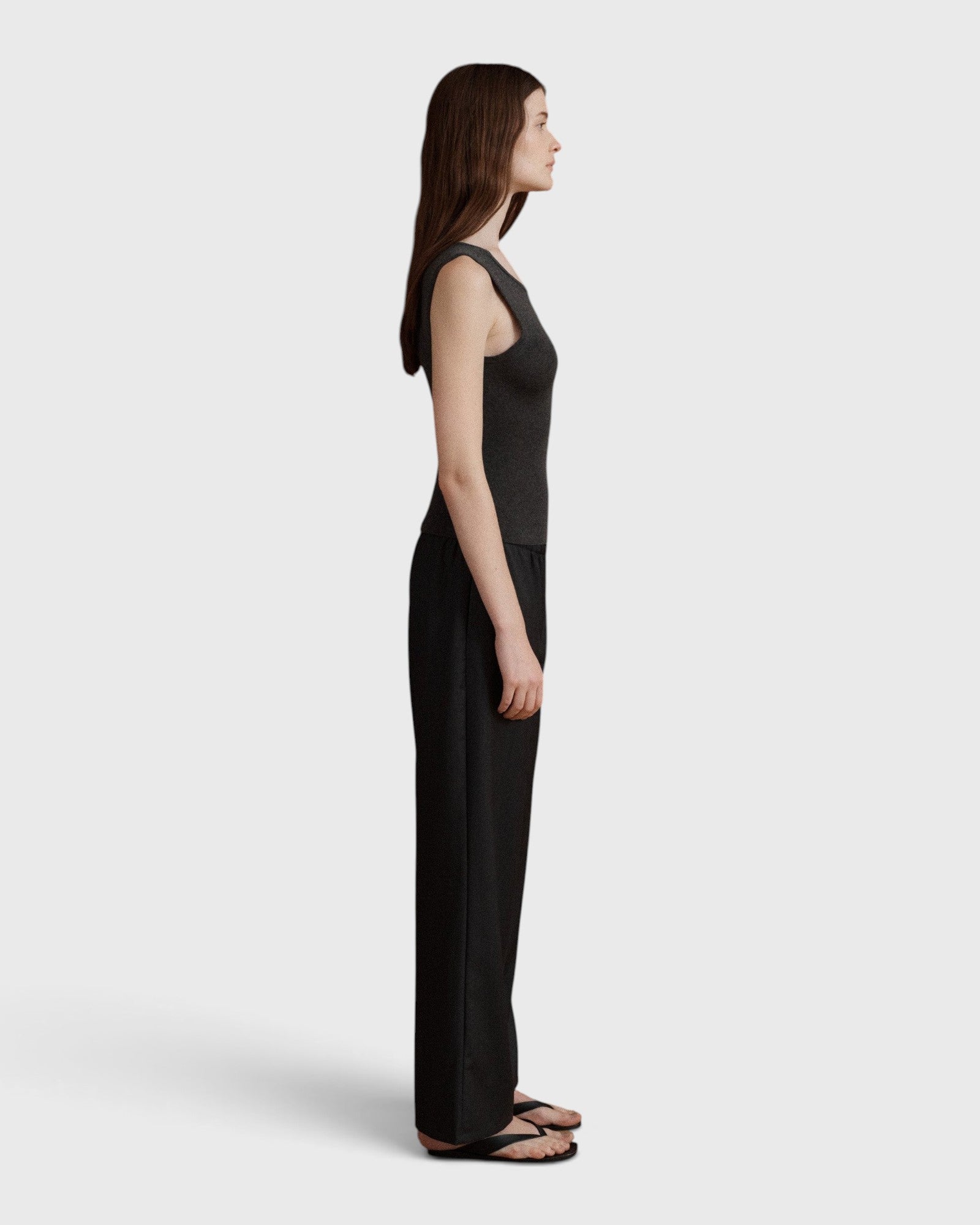 JONES + CO Iris scoop back tank in anthracite wool, cashmere, and silk rib knit worn by a model, side profile view.
