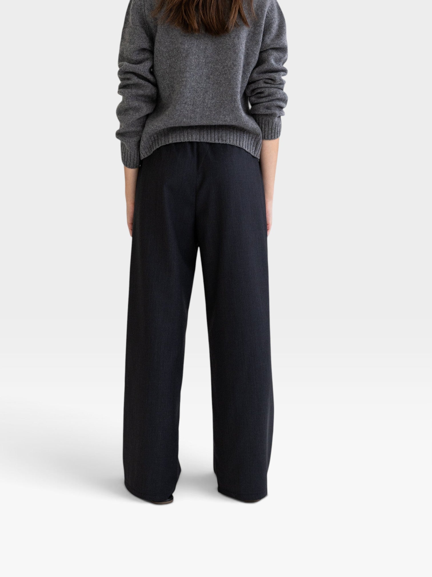 JONES + CO Joanna wool trousers in anthracite featuring a relaxed wide-leg fit and elastic waistband, back view.