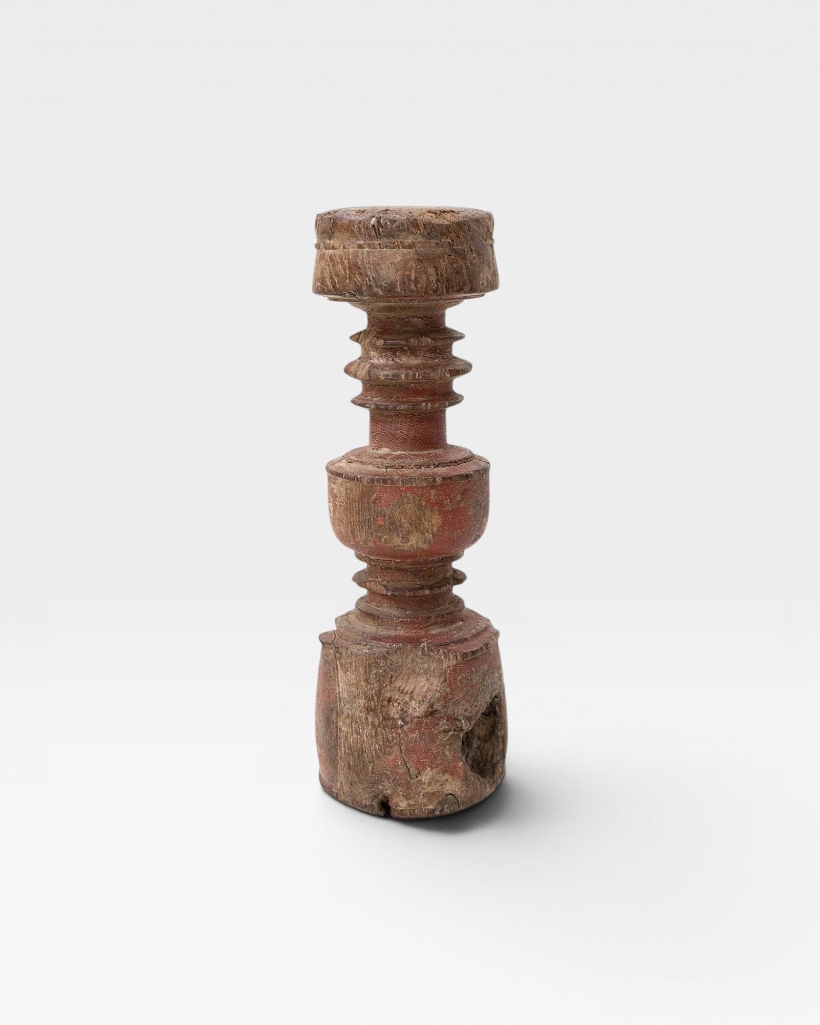 JONES + CO antique rustic wooden pillar with red paint accents and carved details, used as sculptural accent or candle holder.