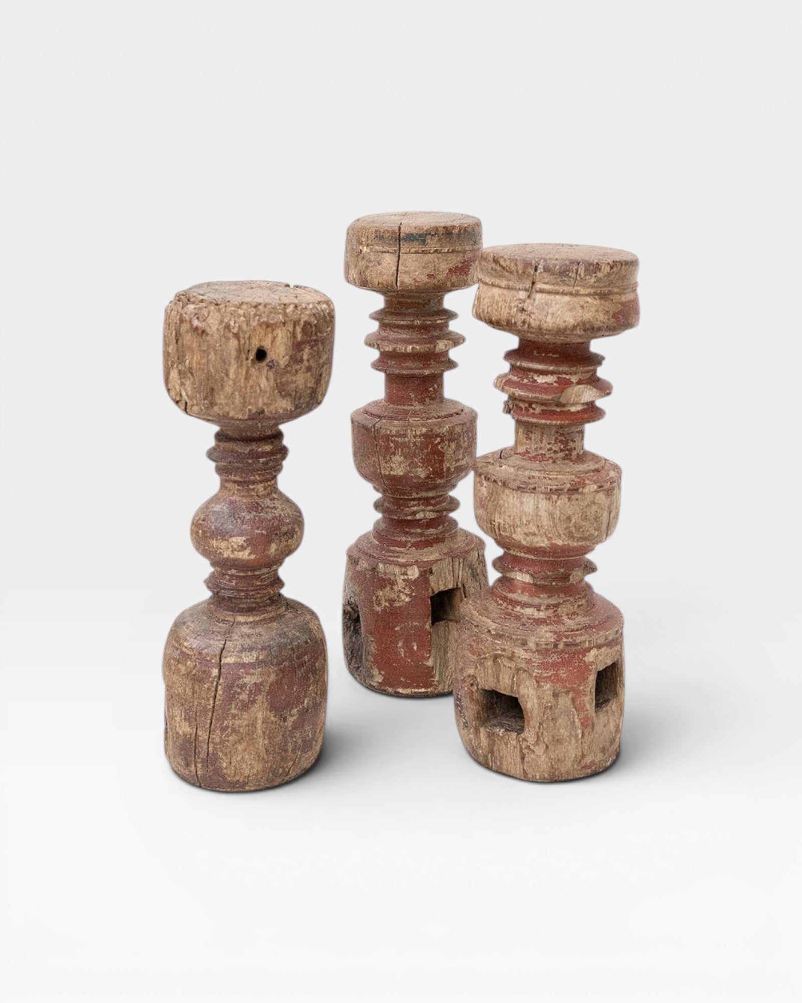 JONES + CO antique rustic wooden pillars, set of 3, with red paint patina and carved details.