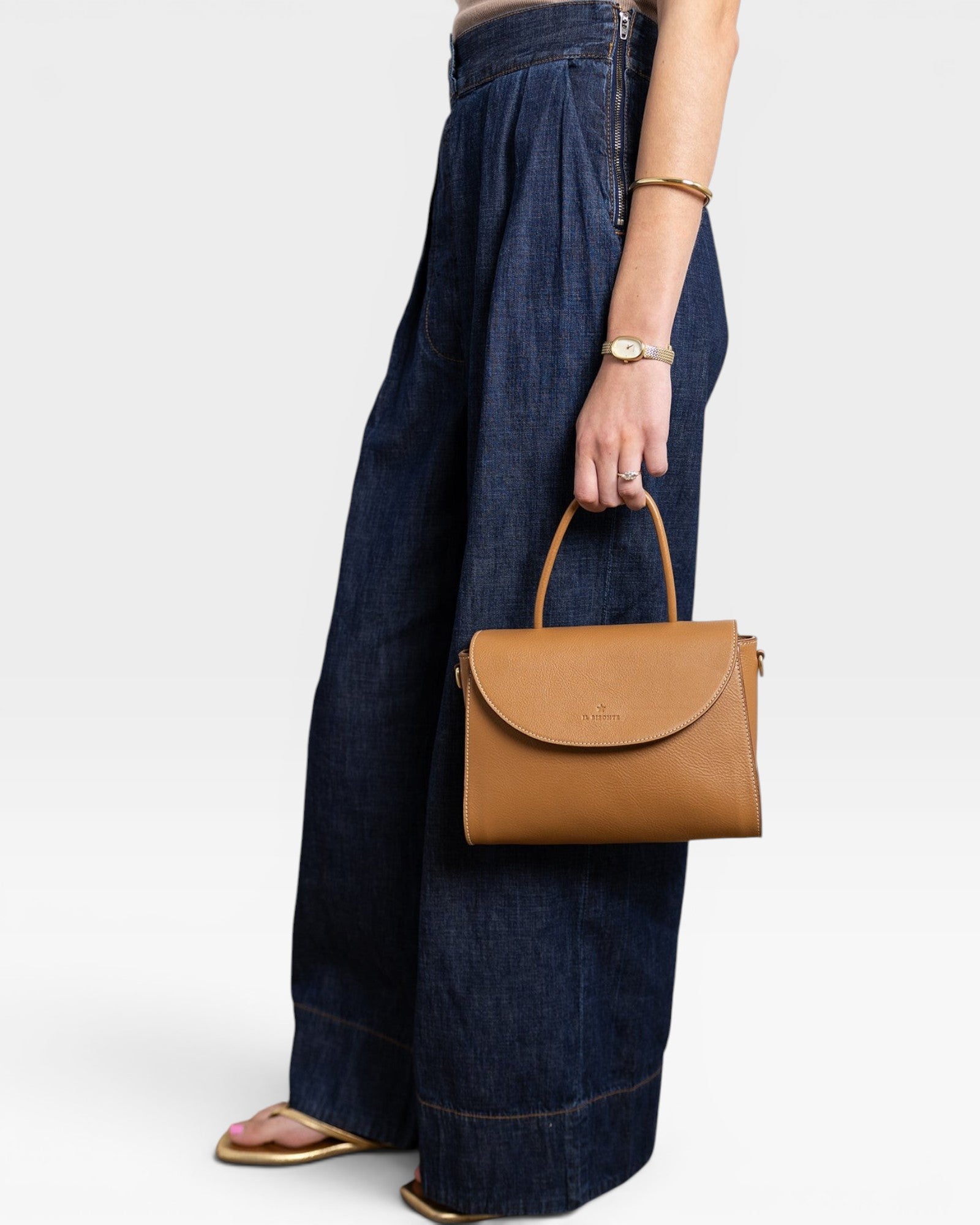 JONES + CO Archive 1978 Linea top handle bag in gianduia brown pebbled leather with flap closure and cotton canvas lining.