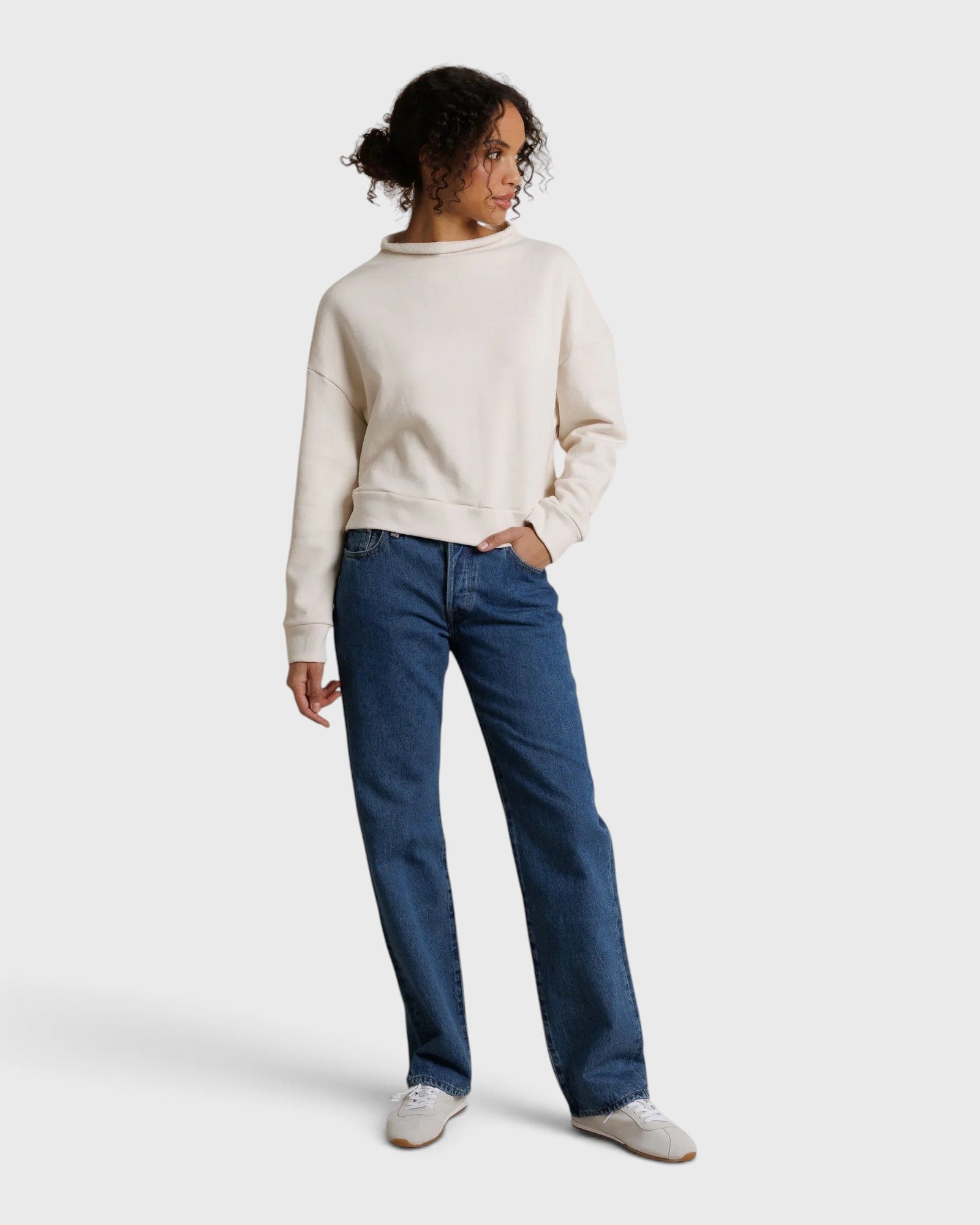 JONES + CO Arden mock neck sweatshirt in sugar cream French terry fabric worn with blue jeans by a female model