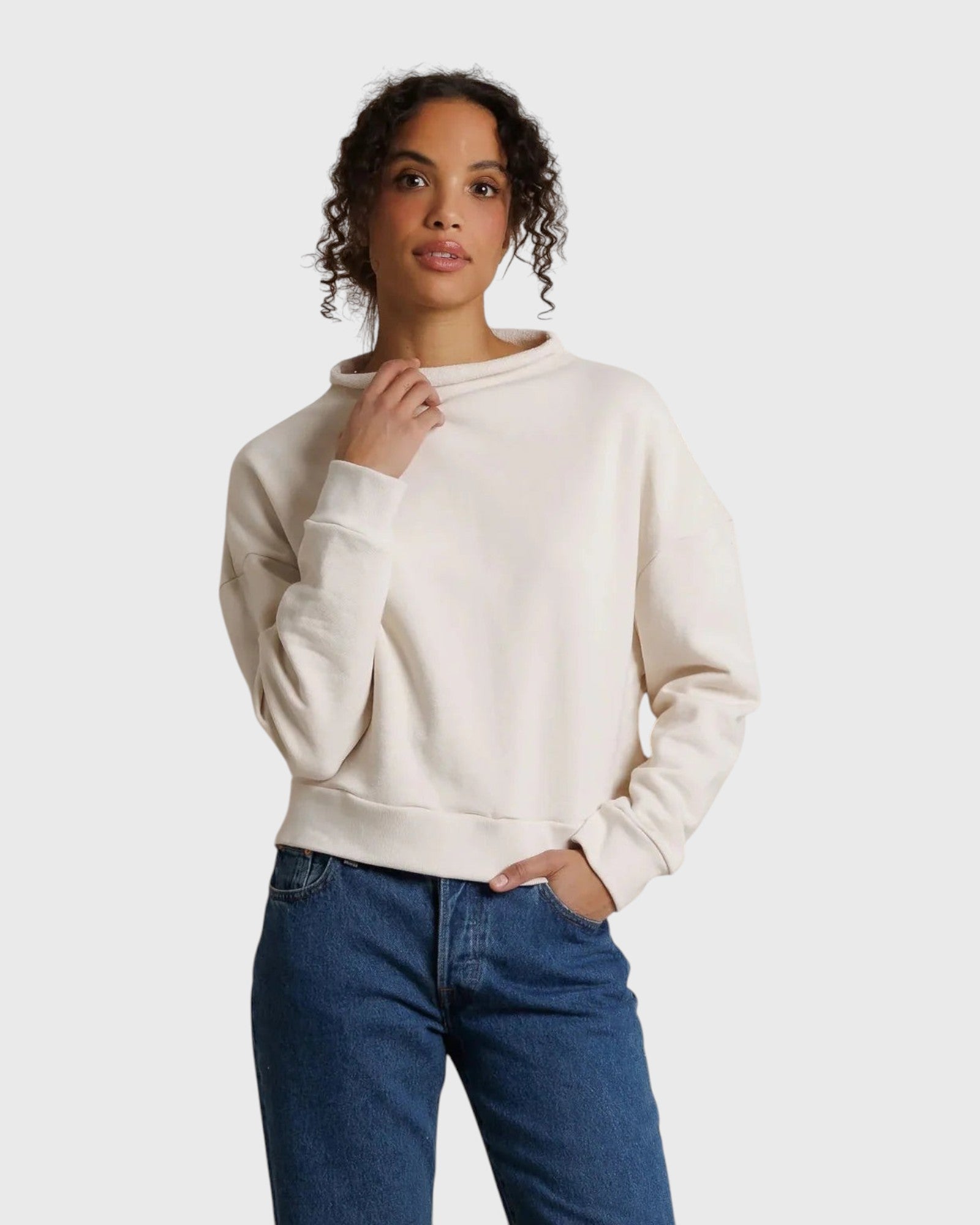 Model wearing JONES + CO Arden mock neck sweatshirt in sugar cream French terry with a boxy fit and long sleeves