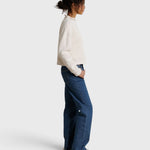 JONES + CO Arden mock neck sweatshirt in sugar white French terry worn by a model with blue jeans, side view
