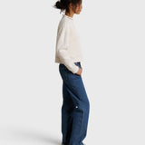 JONES + CO Arden mock neck sweatshirt in sugar white French terry worn by a model with blue jeans, side view