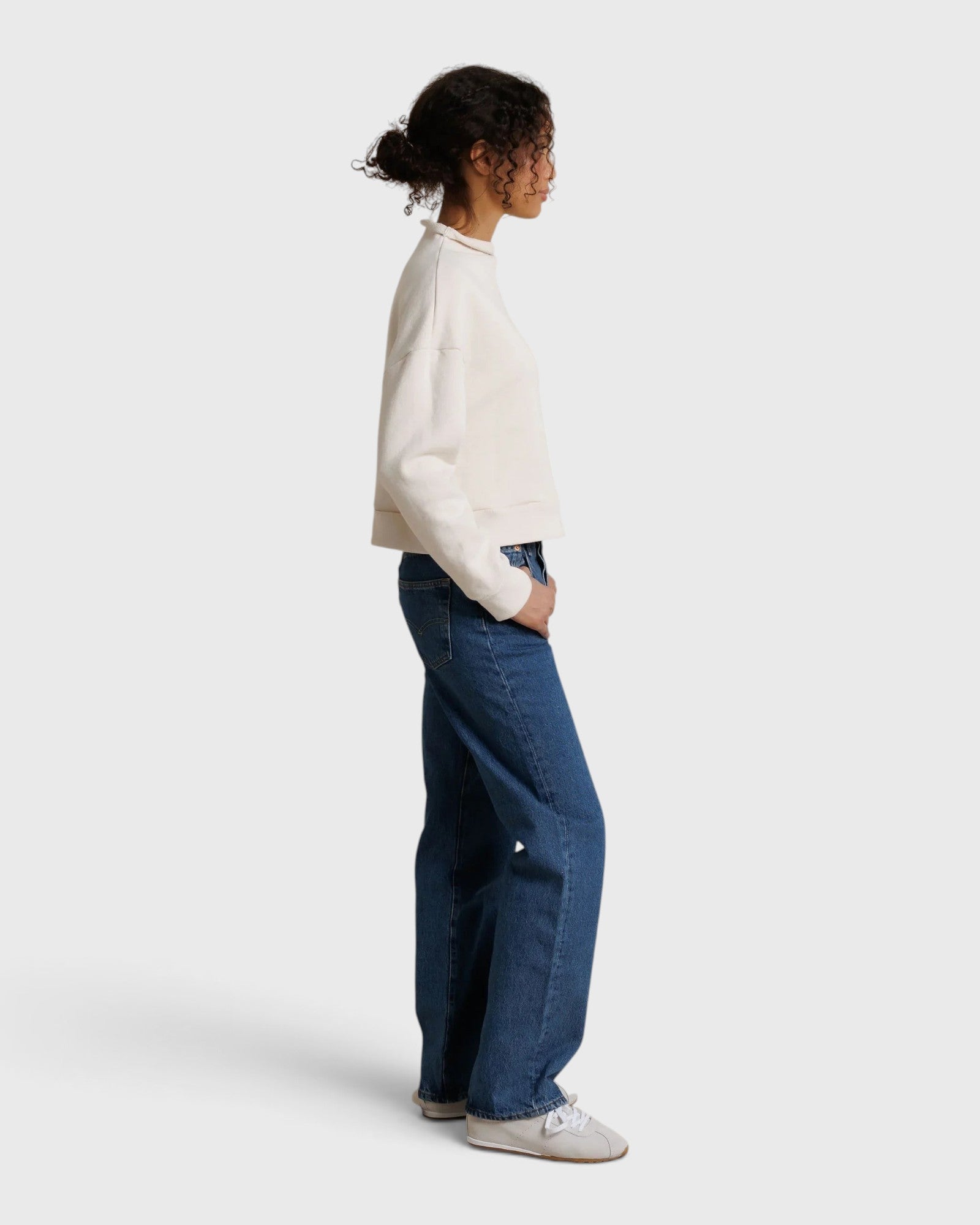 JONES + CO Arden mock neck sweatshirt in sugar white French terry worn by a model with blue jeans, side view
