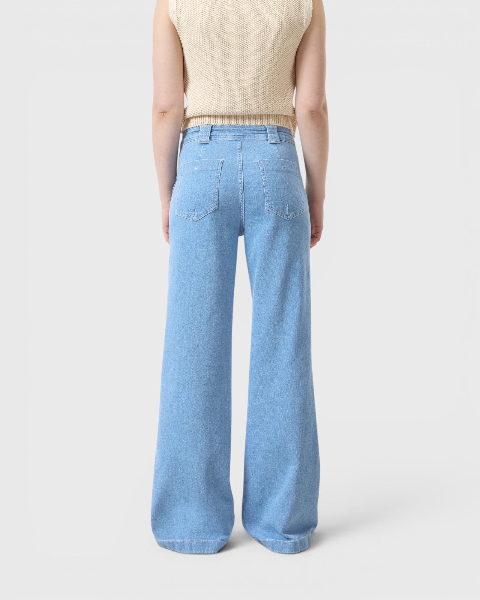 JONES + CO Aria flared jeans in light blue stretch denim with high waist and patch pockets, back view.
