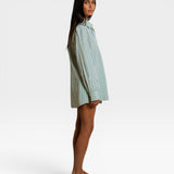 JONES + CO Avalon teal blue and sugar stripe cotton poplin oversized button-down shirt worn by a model, side view.