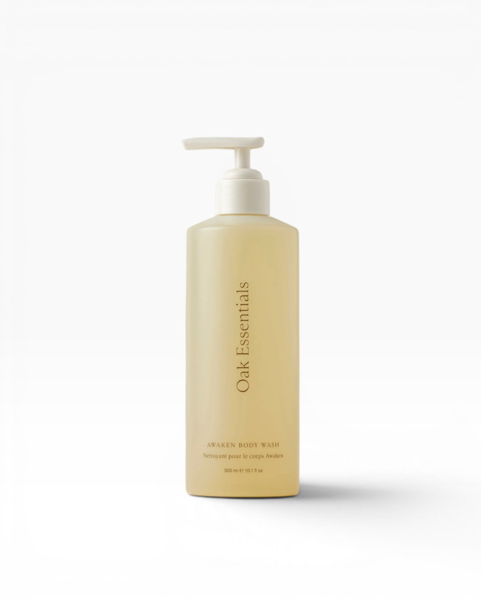 JONES + CO Awaken Body Wash, a pale yellow liquid in a translucent pump bottle with botanical citrus scent.