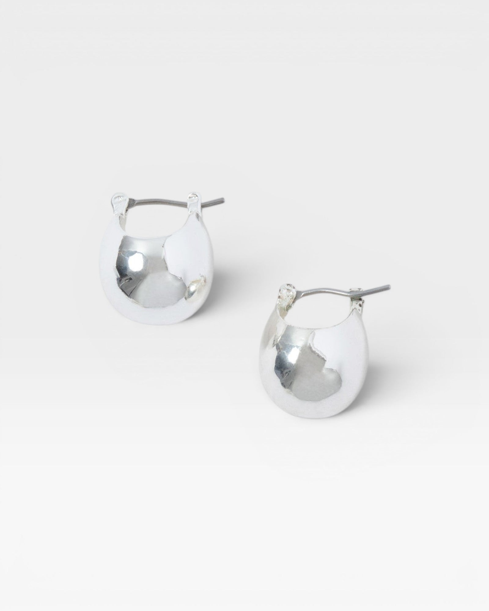 JONES + CO Baby Keel Hoop mini hollow oblong silver hoop earrings with hinged fastening.