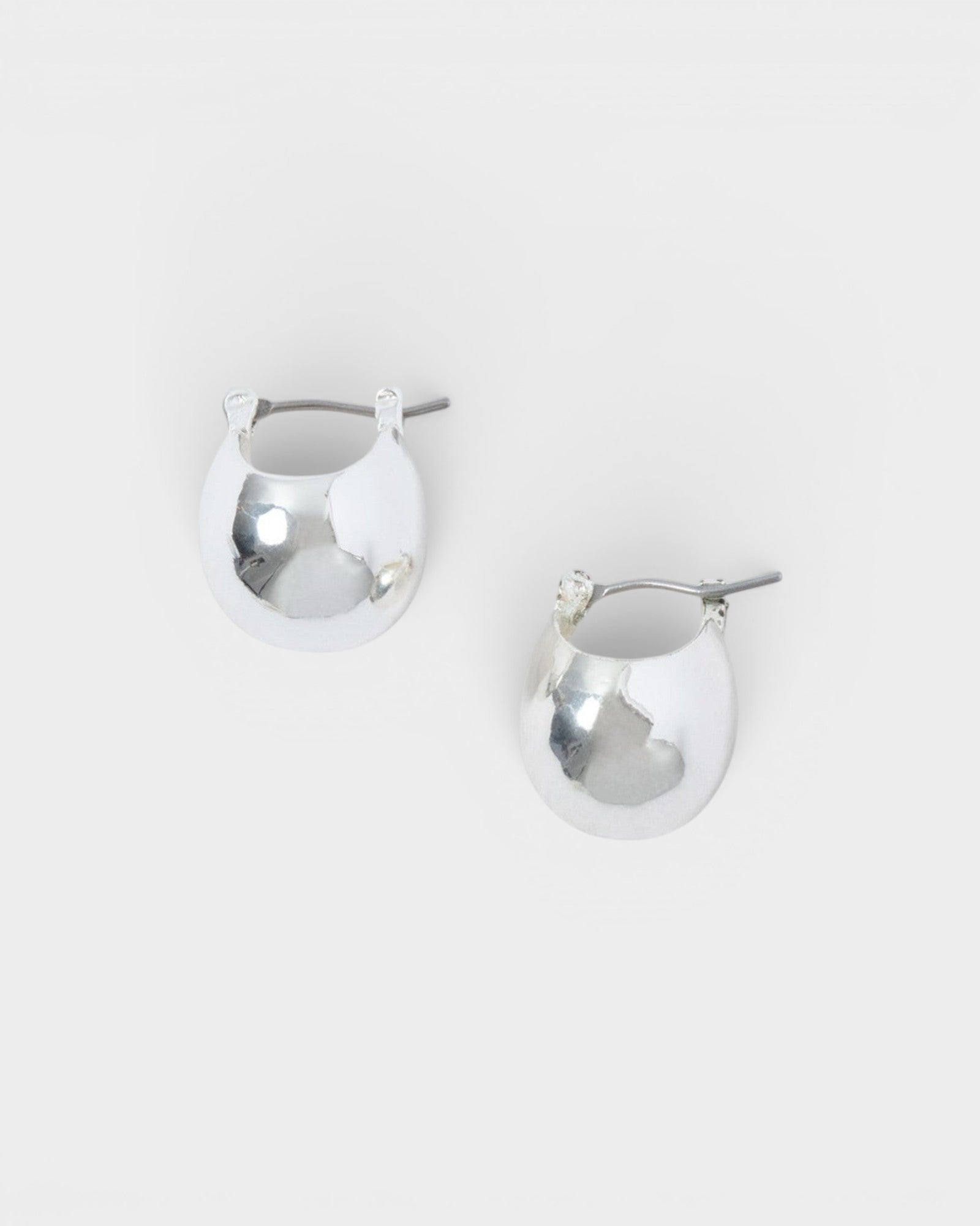 JONES + CO Baby Keel Hoop mini hollow oblong silver hoop earrings with hinged fastening.