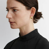 JONES + CO Baby Keel Hoop earrings in gold. Mini hollow oblong hoops with hinged fastening.