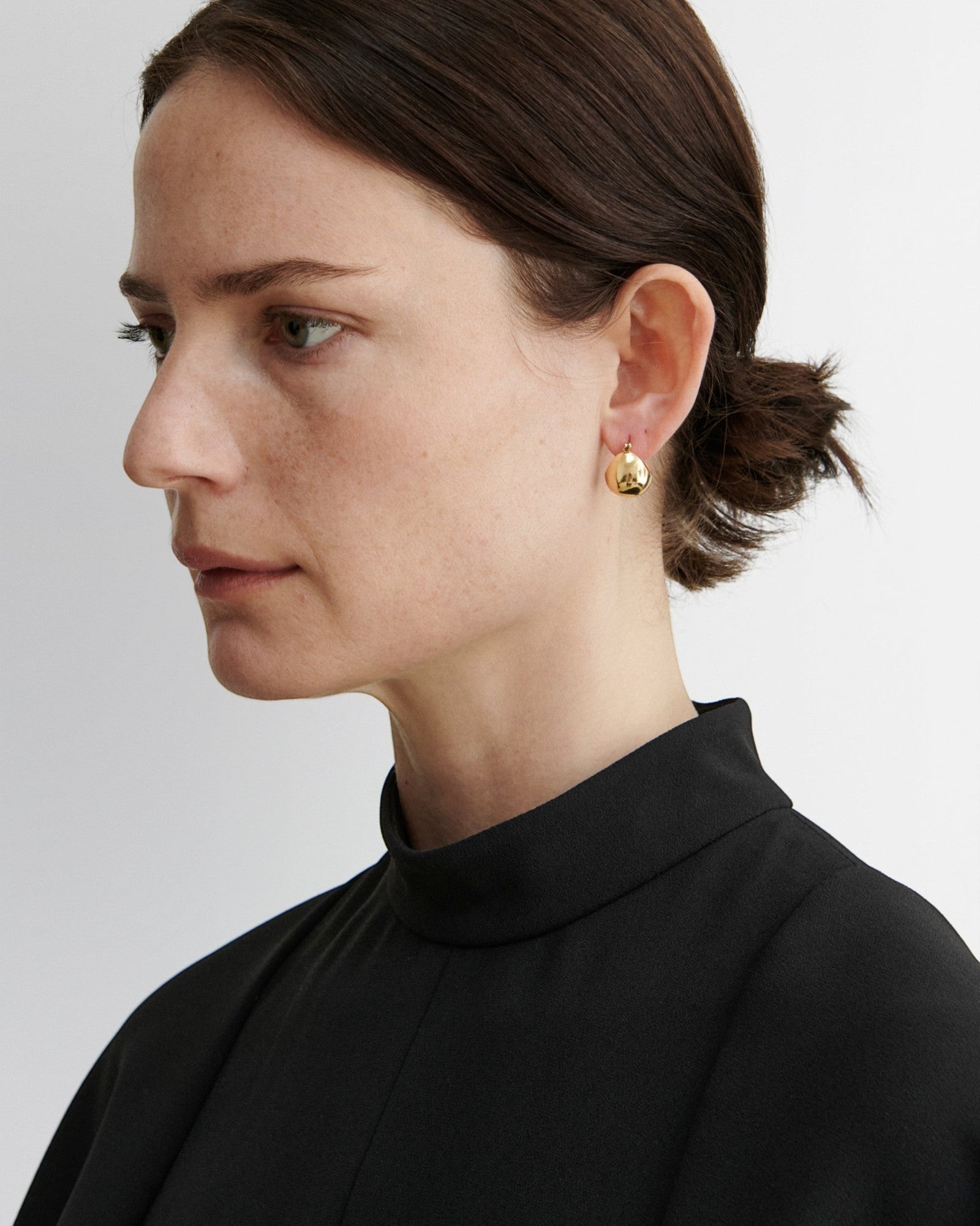 JONES + CO Baby Keel Hoop earrings in gold. Mini hollow oblong hoops with hinged fastening.