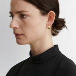JONES + CO Baby Keel Hoop earrings in gold. Mini hollow oblong hoops with hinged fastening.
