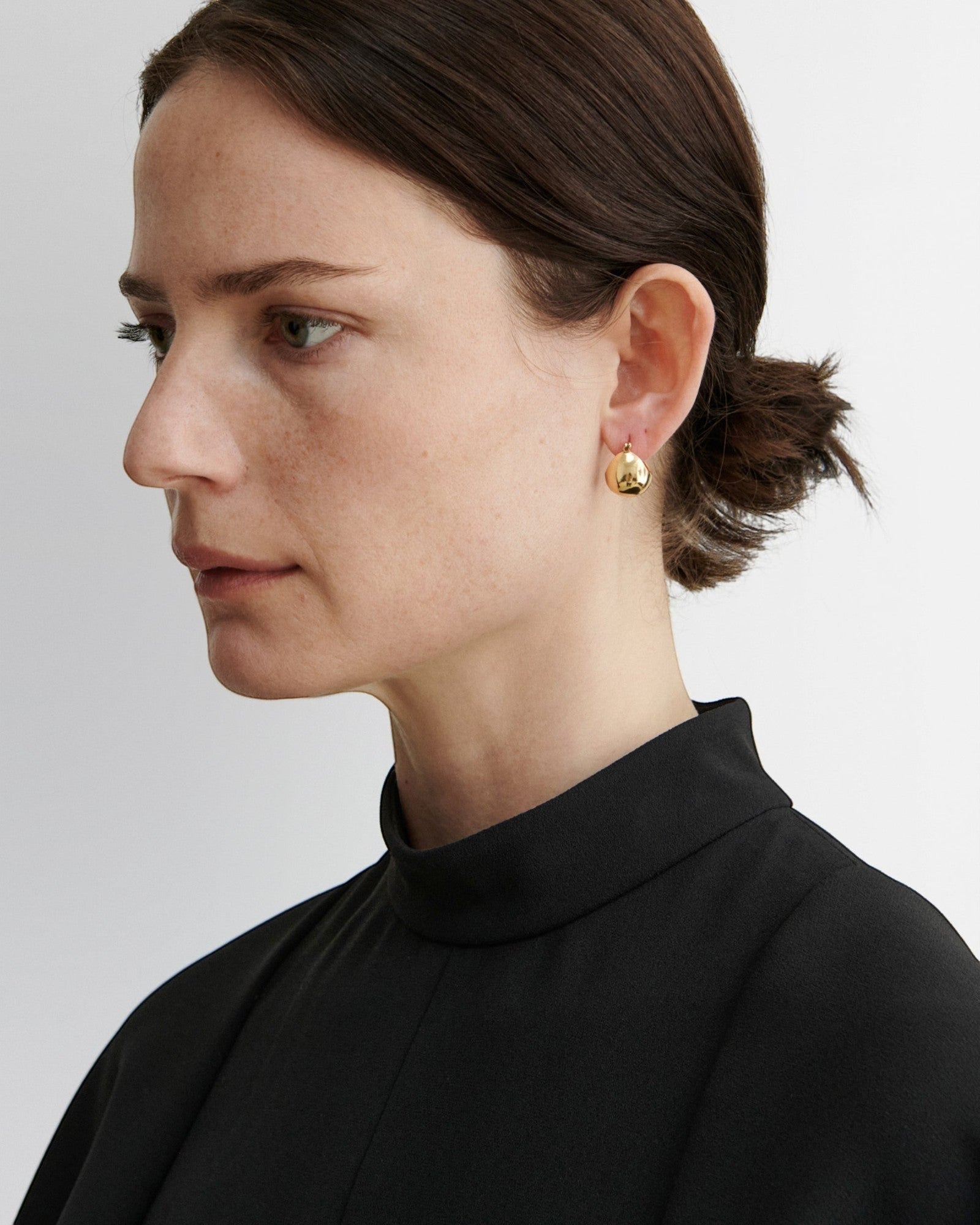 JONES + CO Baby Keel Hoop earrings in gold. Mini hollow oblong hoops with hinged fastening.
