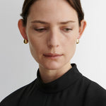 JONES + CO Baby Keel Hoop gold hollow oblong hoop earrings with hinged fastening.