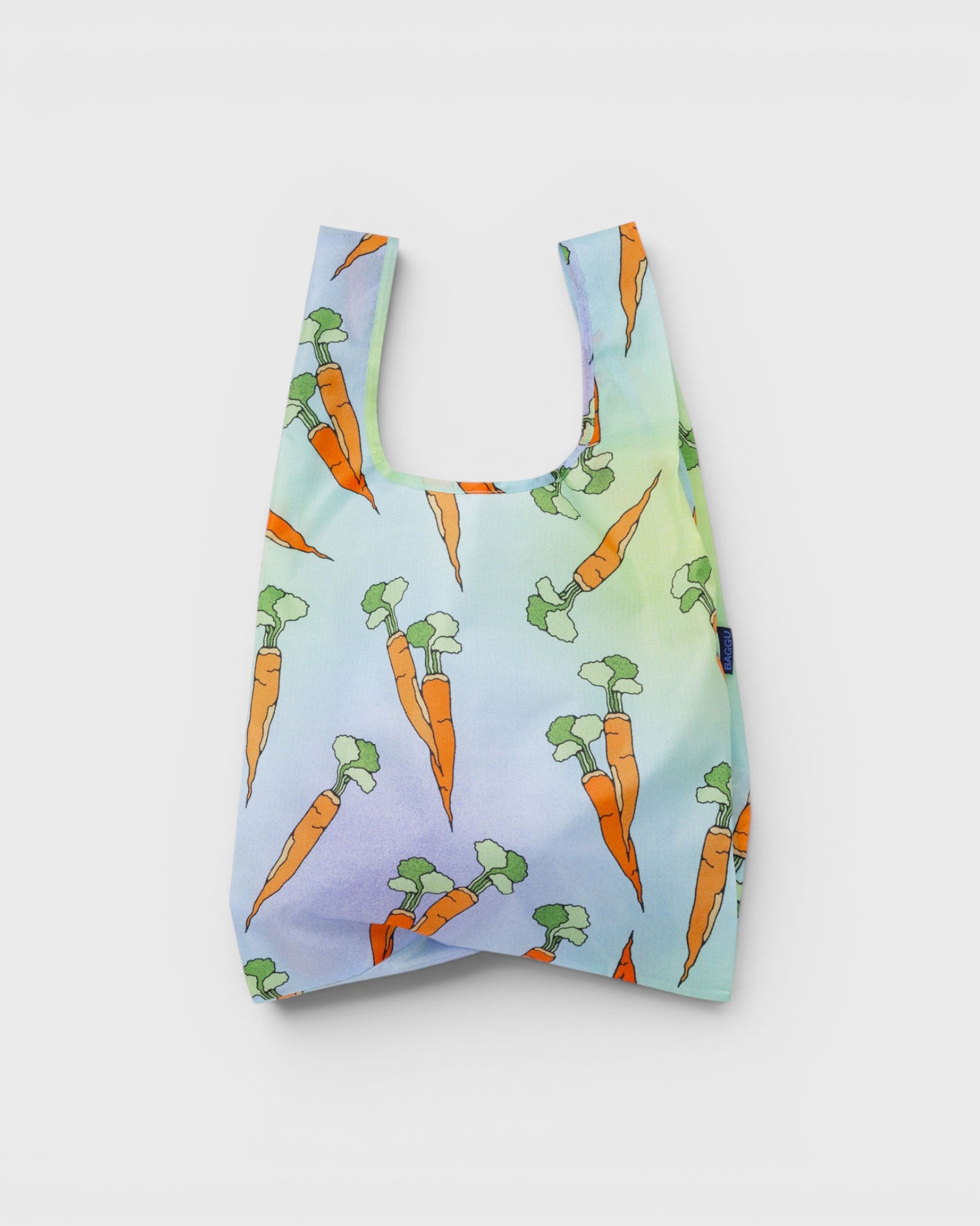 JONES + CO Baggu reusable nylon grocery bag featuring a colourful carrot pattern on a soft pastel gradient background.