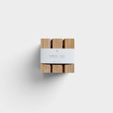 JONES + CO bamboo shower steamer tray with a white paper band, top-down view on a neutral background.