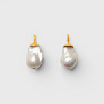 JONES + CO Go For Baroque earrings featuring large organic creamy white baroque pearls set in 14k gold over brass.