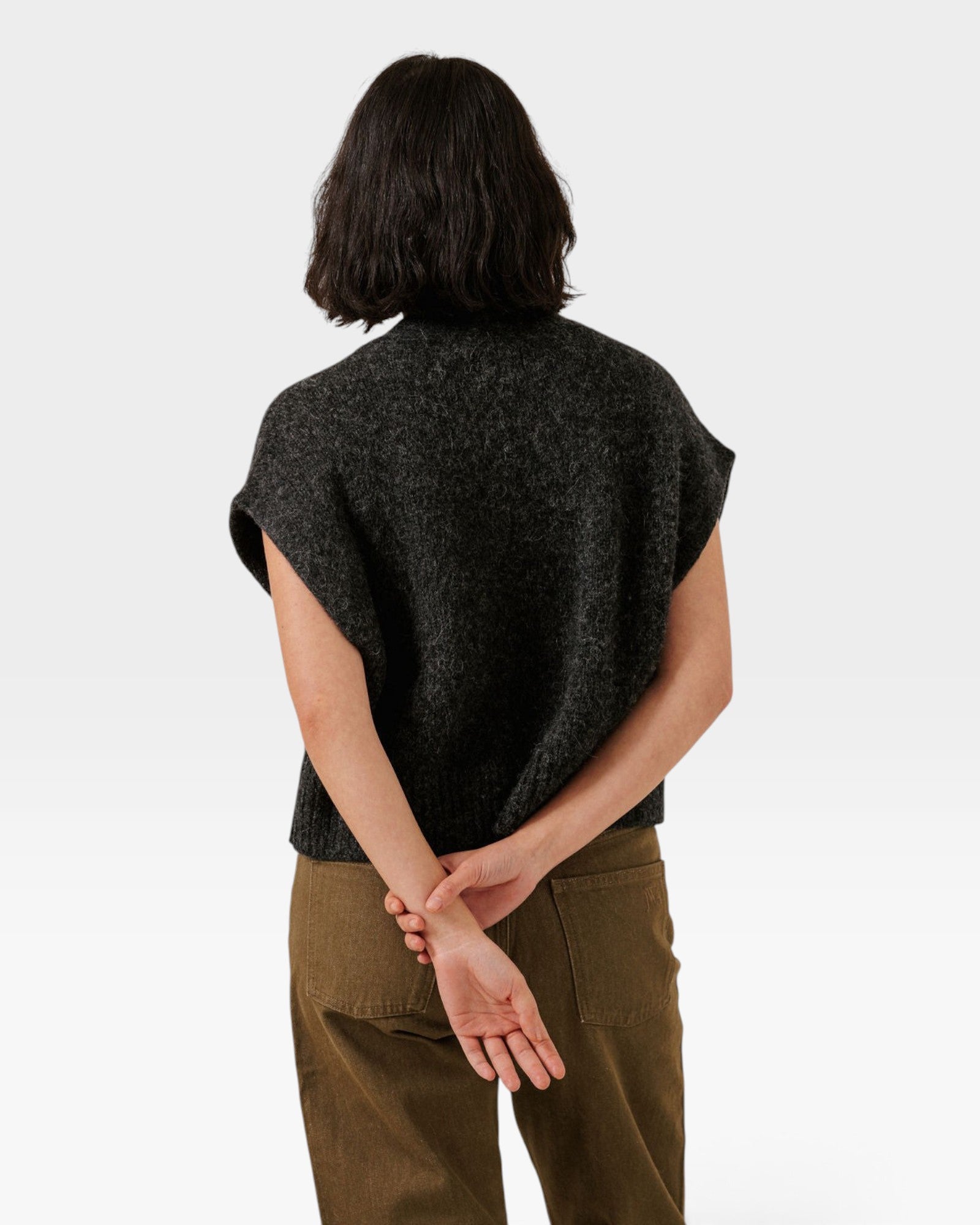 Back view of a model wearing a JONES + CO basalt grey alpaca blend button-down vest with a straight hem.