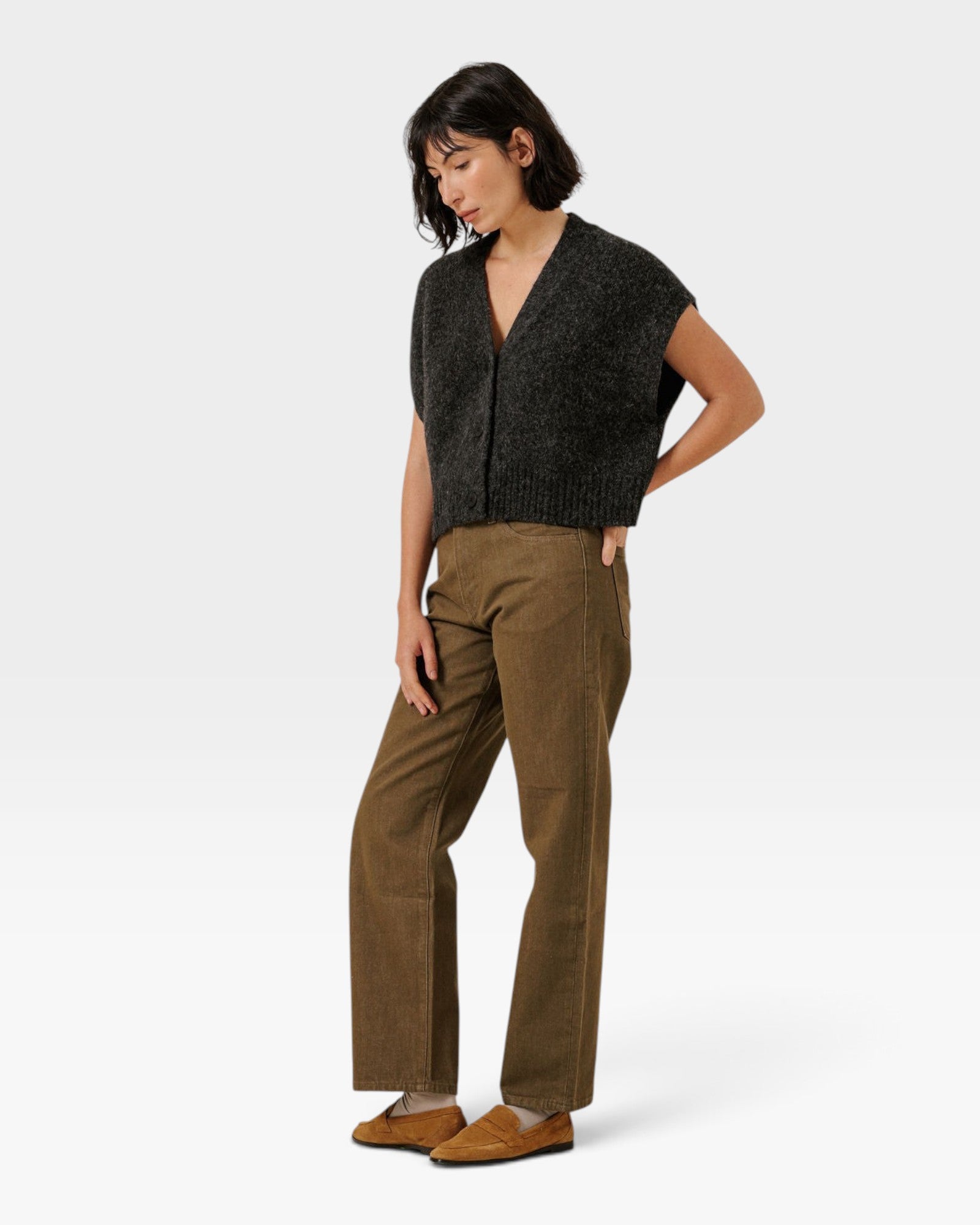 JONES + CO cropped basalt grey alpaca blend button-down vest worn by a woman with brown trousers and loafers.
