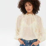 JONES + CO beige sheer blouse with ruffled high neckline and voluminous sleeves, featuring delicate floral embroidery.
