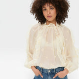 JONES + CO beige sheer blouse with ruffled high neckline and voluminous sleeves, featuring delicate floral embroidery.