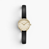JONES + CO Beverly watch featuring a gold case, minimalist cream dial, and black leather strap on a white background.