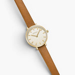 JONES + CO Beverly watch featuring a gold case, cream dial, and brown leather strap on a white background