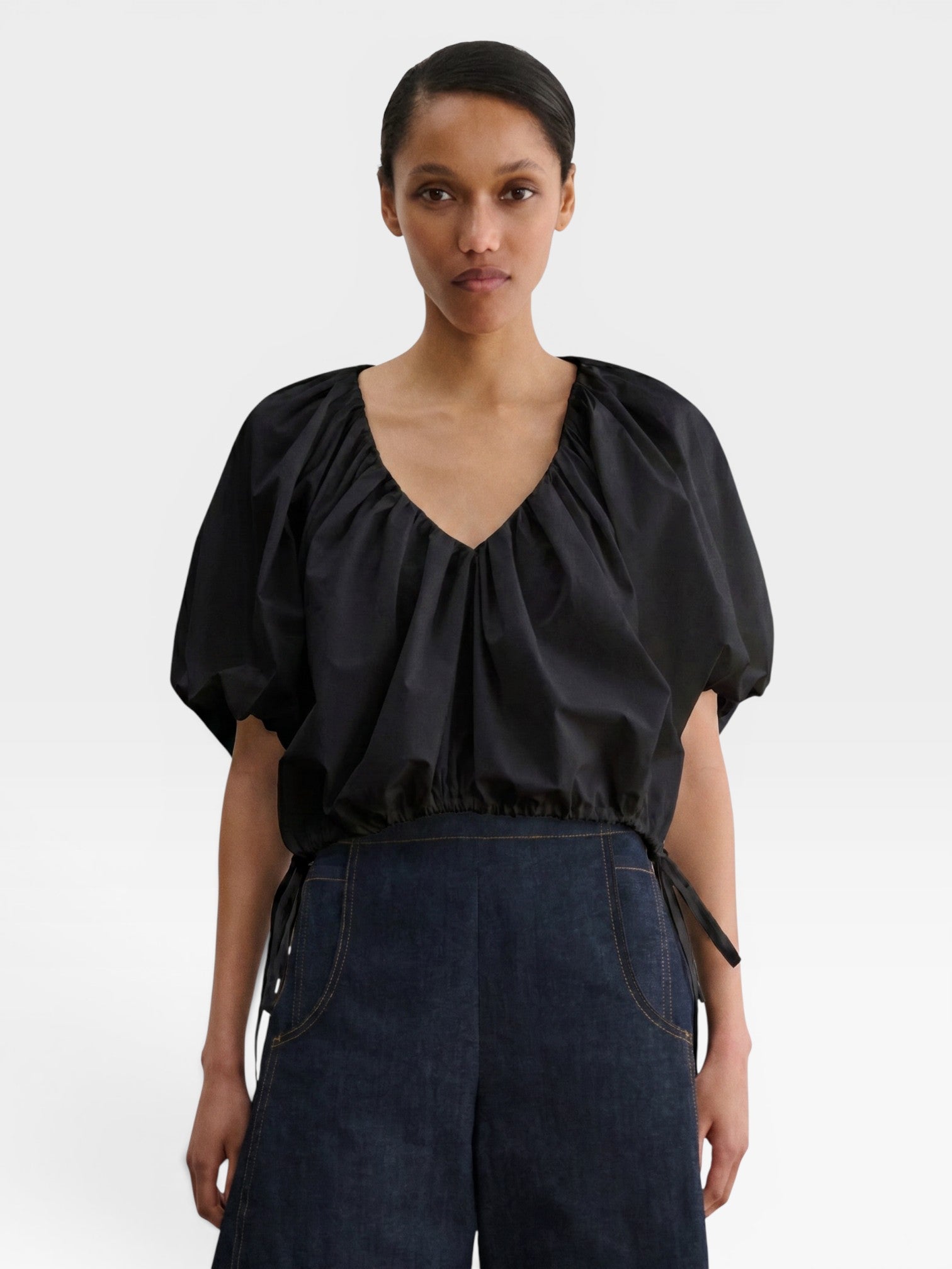 JONES + CO black organic cotton poplin cropped V-neck top with voluminous balloon sleeves and adjustable waist ties.