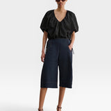 JONES + CO black organic cotton poplin cropped V-neck balloon top with adjustable drawstring waist on a model