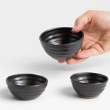 JONES + CO handcrafted black ceramic little bowls held in a hand, perfect for snacks or home decor.