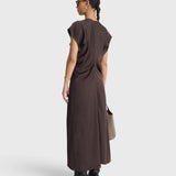 Model wearing apiece apart JONES + CO black coffee brown bias-cut viscose maxi dress with draped silhouette and V-neckline.