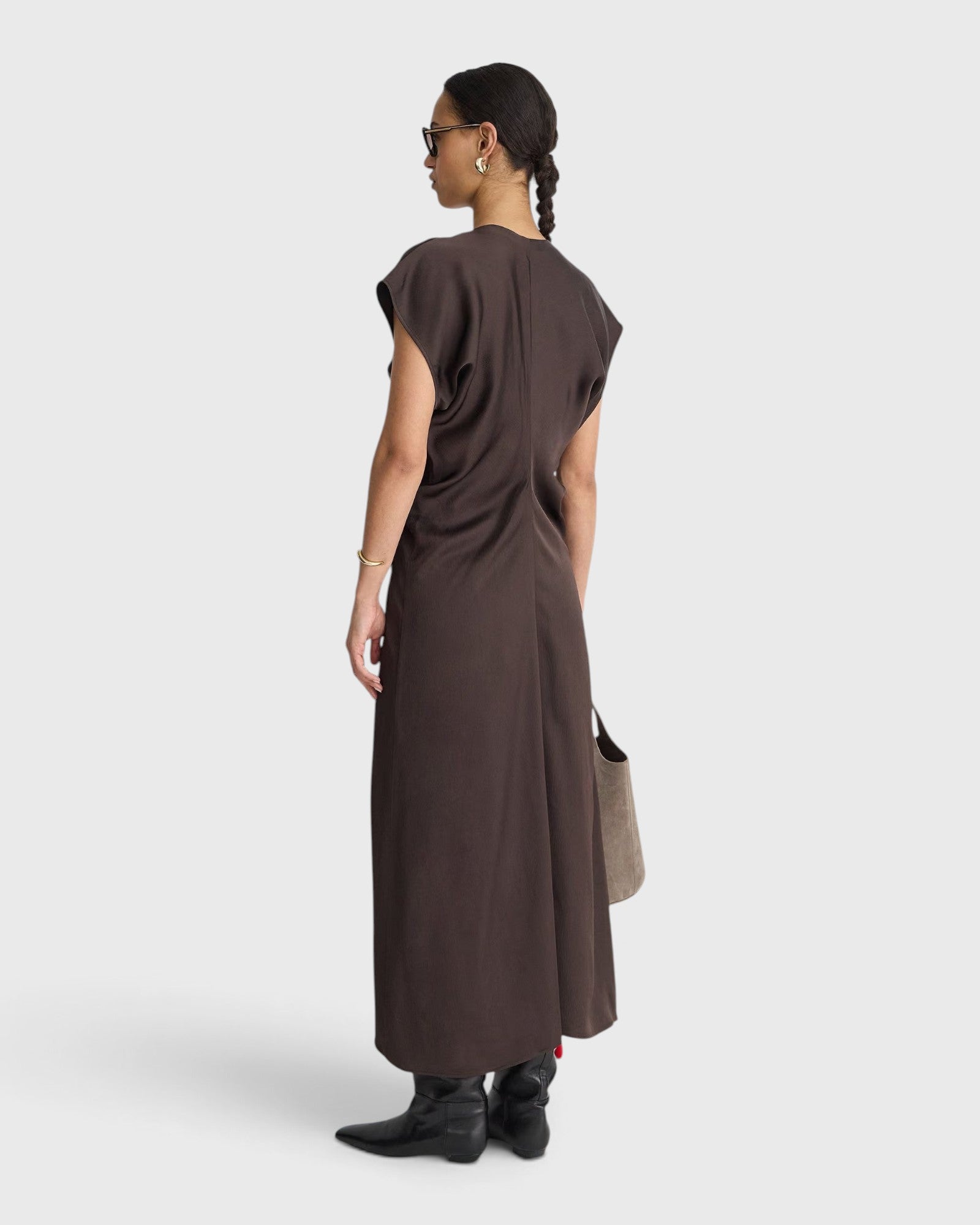 Model wearing apiece apart JONES + CO black coffee brown bias-cut viscose maxi dress with draped silhouette and V-neckline.