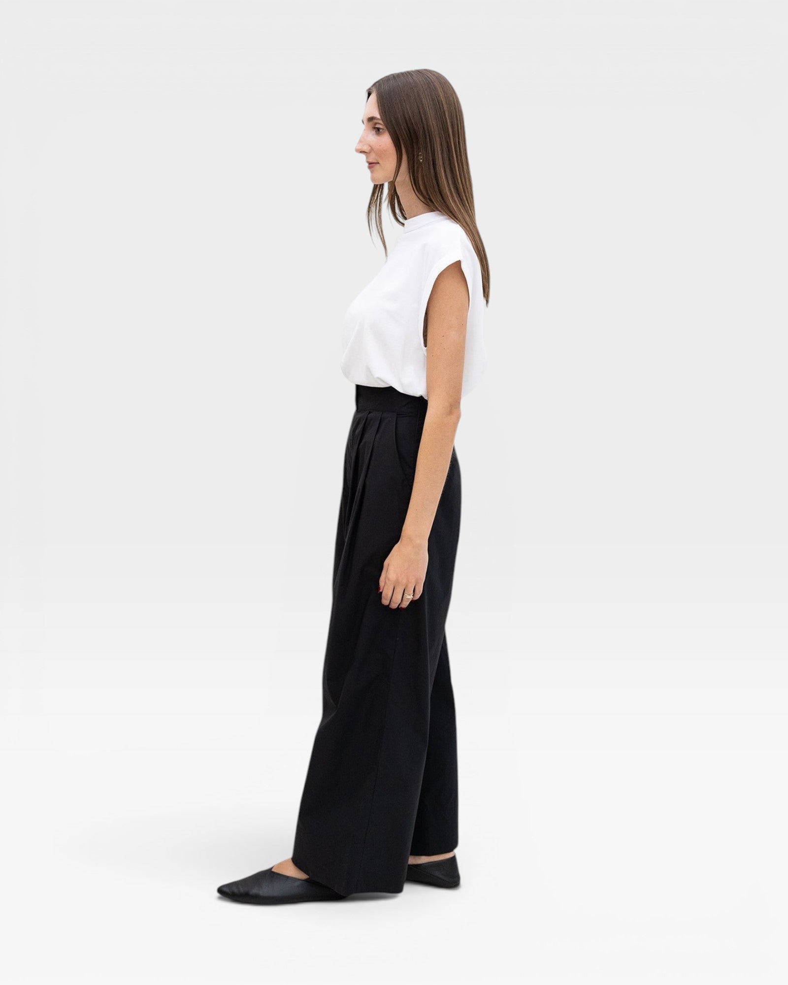 JONES + CO black high-waisted wide-leg cotton trousers with pleats, worn by a model.