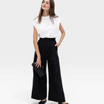 JONES + CO black high-waisted wide-leg cotton trousers with pleats, paired with a white top.